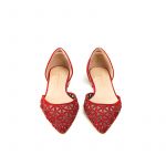 Ballerine rosse a punta in camoscio con l'iconico pattern laserato e piccole borchie dorate, modello